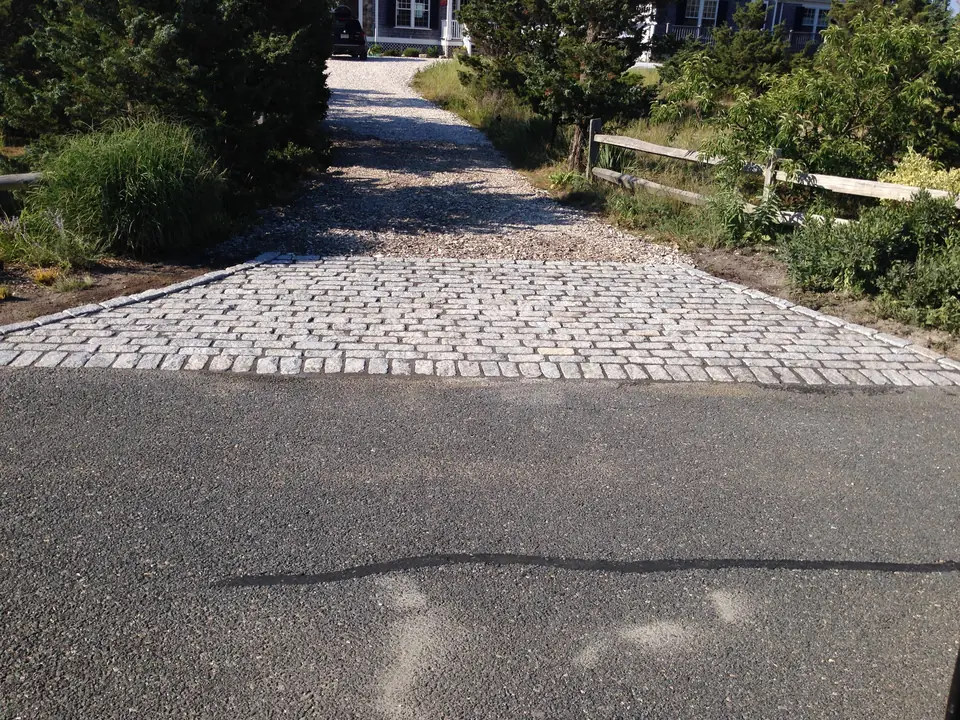 Cobblestone apron at the foot of a crushed stone driveway