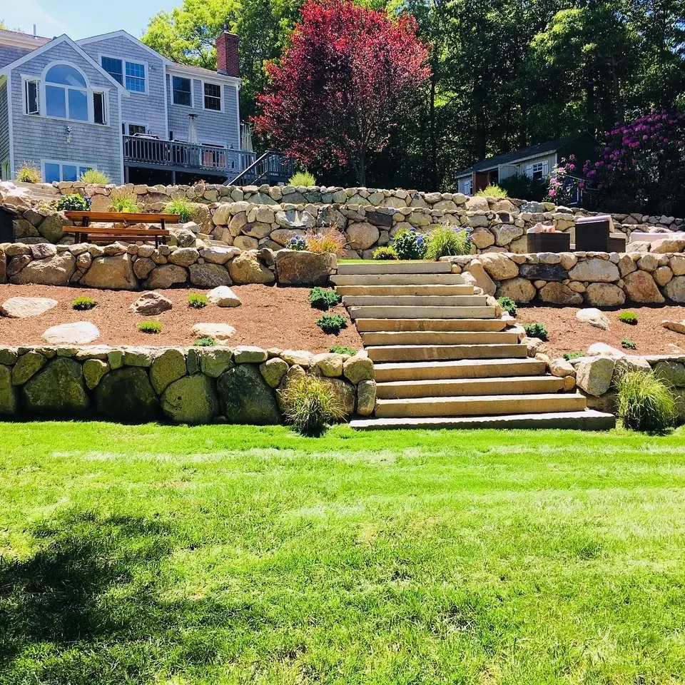 Terraced boulder walls with granite steps up to the patio